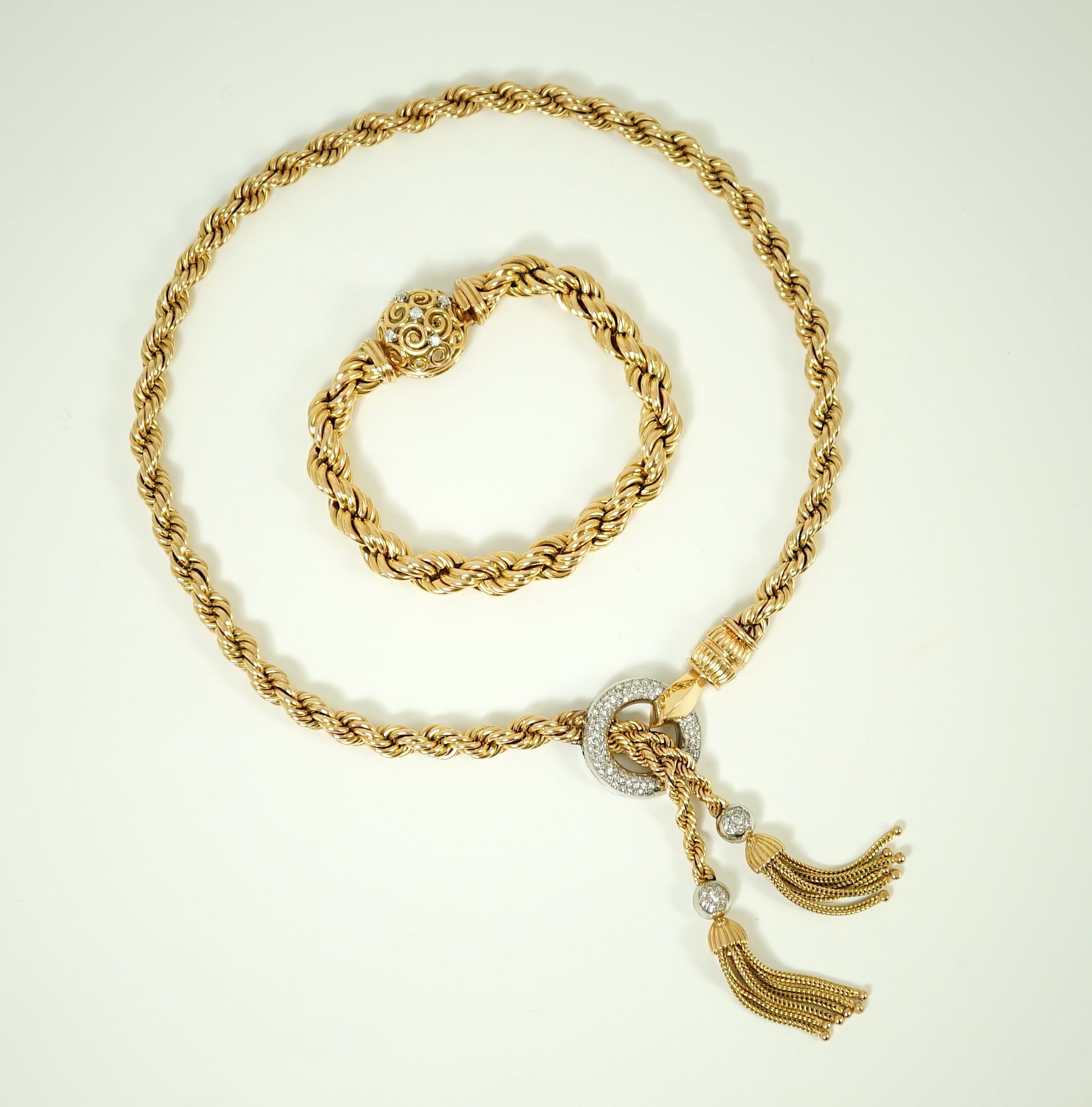 A modern heavy Middle Eastern gold and diamond set rope twist drop tassel necklace, together with a similar gold and diamond set bracelet